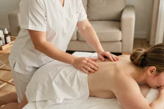 Masseuse professionnelle effectuant un massage à domicile dans un salon moderne, service Wecassa de bien-être à domicile